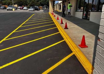 Fresh yellow crosshatch striping along a commercial building