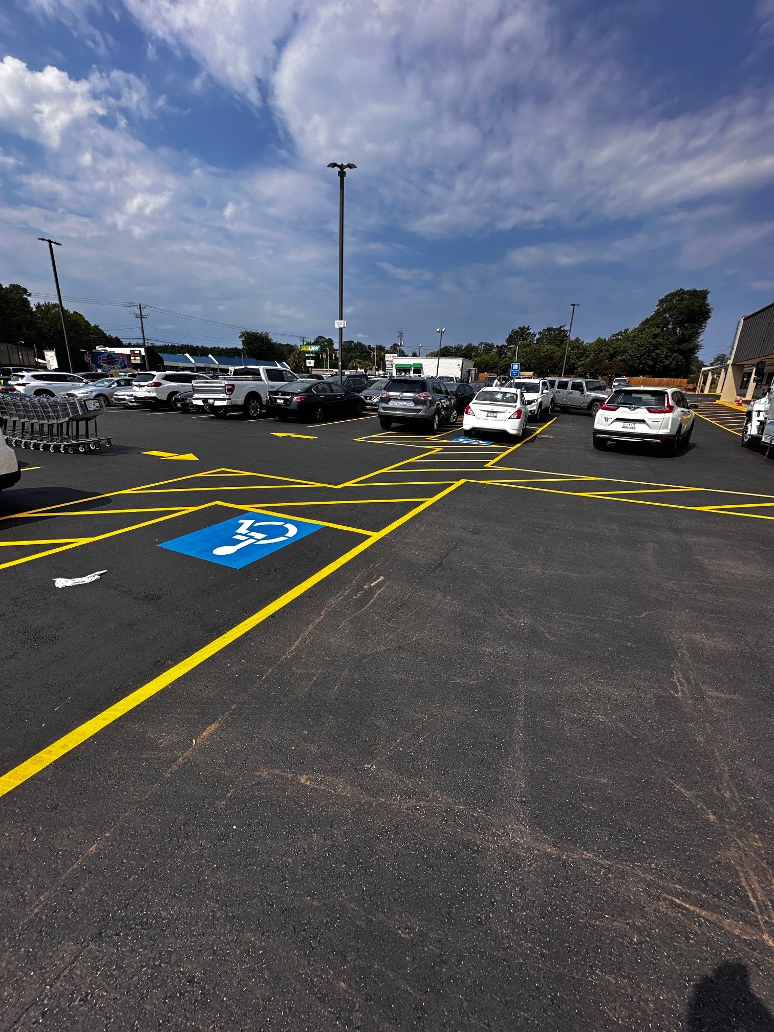 commercial parking lot with new pavement and line striping, ada compliant parking