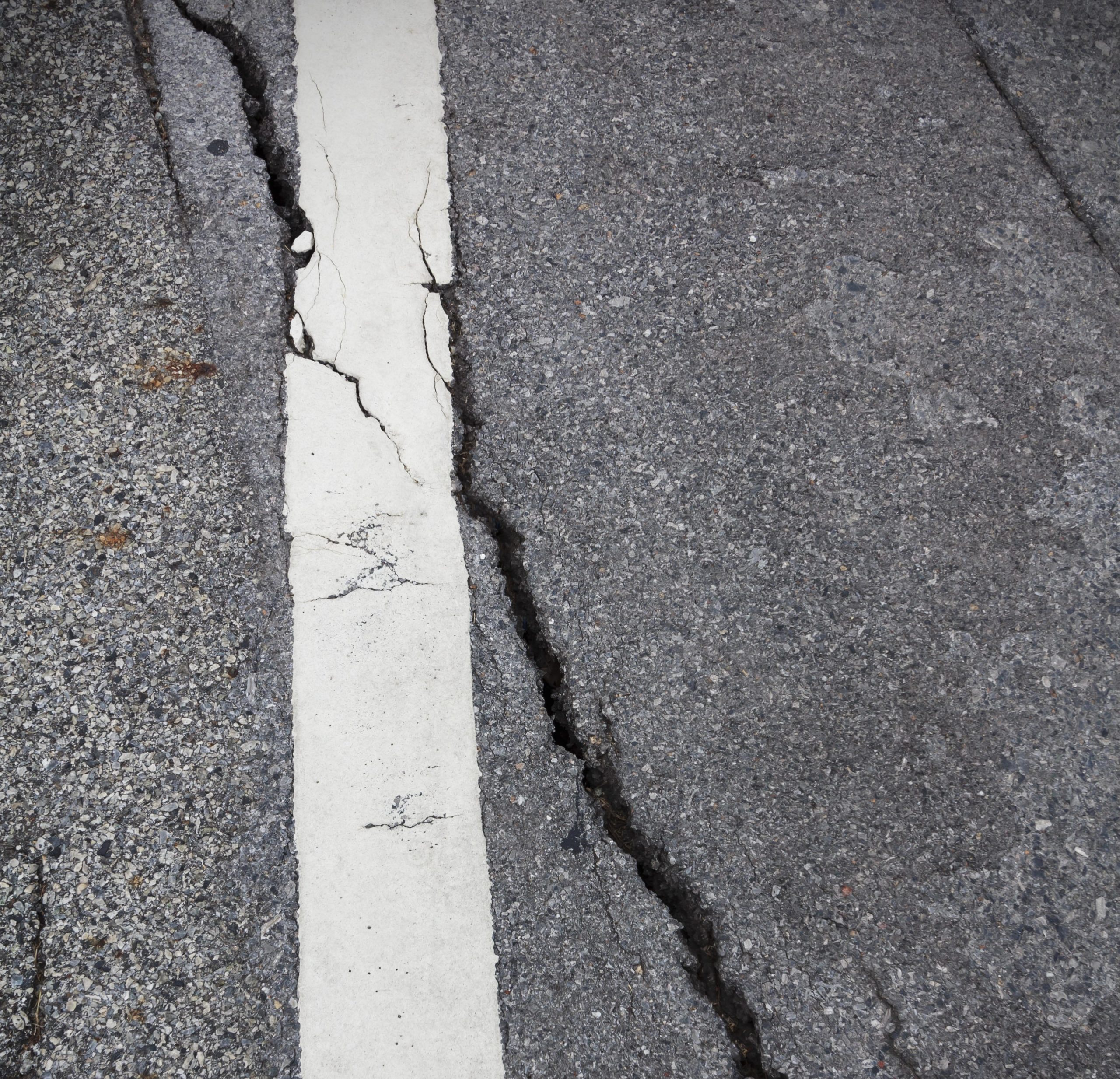 cracked pavement in parking lot, asphalt repair services needed
